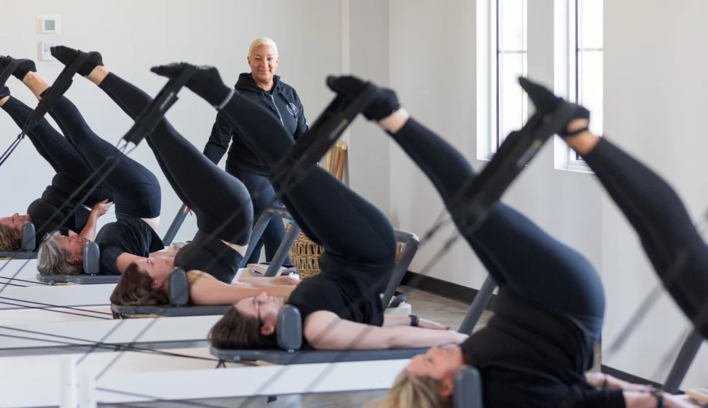 Pilates teacher training instructor observing students on the reformers at Right Balance Pilates in Delaware